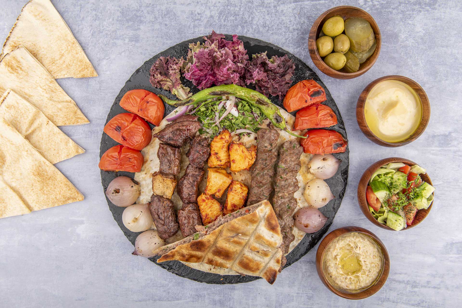Mixed grill platter with kebabs, rice, hummus, and fresh sides